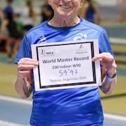 Emma Maria Mazzenga sourit en montrant le certificat de son record aux 200 mètres, bouclé en moins de 55 secondes.