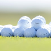 Gros plan de balles de golf déposées sur un terrain.