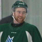 Joueur de hockey barbu souriant.