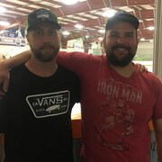 Caleb Ryan et Karl Chaschin se font une accolade près de la patinoire où se déroule le tournoi Hockey en fête. 
