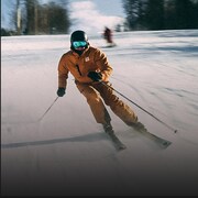Un homme descend une pente en ski alpin.