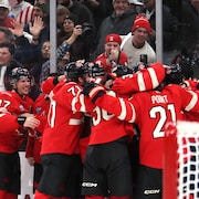 Des joueurs de hockey célèbrent sur la glace. 