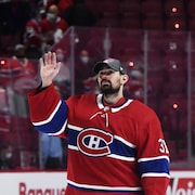 Un gardien de but au hockey salue la foule.