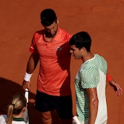 Deux joueurs de tennis sont près l'un de l'autre pendant une pause de jeu.