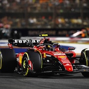 Une monoplace de F1 roule un circuit éclairé. 