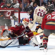 Une gardienne de but se dresse tel un mur devant une attaque lors d'un match de hockey f&eacute;minin professionnel.