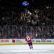 Un joueur de hockey regarde la foule qui c&eacute;l&egrave;bre son but.