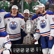 Connor McDavid et ses coéquipiers entourent le trophée Clarence Campbell.