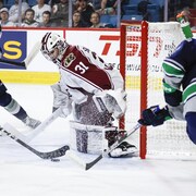Jared Davidson et Dylan Guenther des Thunderbirds tentent de marquer.