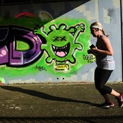 Elle passe devant un mur couvert de graffitis.