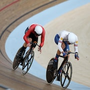 À vélo, Dylan Bibic poursuit Ethan Vernon sur la piste intérieure.