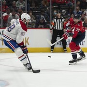 Un joueur de hockey bloque une rondelle lancée par un adversaire.