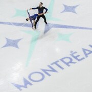 Deux patineurs artistiques exécutent leur programme sur la glace.