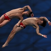 Les deux plongeurs effectuent un saut. 