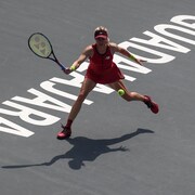 Une joueuse de tennis s'apprête à frapper la balle.