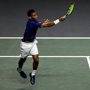 Un joueur de tennis effectue un coup droit lors d'un match.