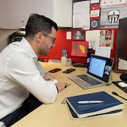 Un homme participe à un cours de langue en ligne sur son ordinateur portable.