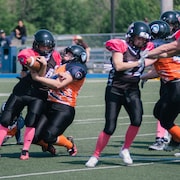 Une femme se fait plaquer au football. 