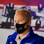 Un pilote de Formule 1, masqué, durant une conférence de presse.