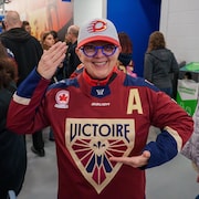 Une partisane montre son chandail de la Victoire et sa casquette de la Charge.