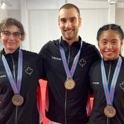 Trois judokas canadiens sourient pour la photo avec leurs médailles autour du cou.
