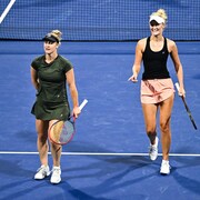 Deux joueuses de tennis marchent sur le court.