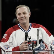 Guy Lafleur, qui porte le chandail du Canadien de Montréal, tient un micro.