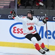 Le hockeyeur Macklin Celebrini célèbre son but.