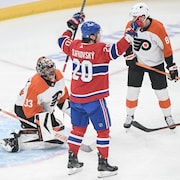 Juraj Slafkovsky lève les bras pour célébrer un but devant le gardien des Flyers Samuel Ersson et son défenseur Cam York.