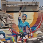 Plan large sur la murale, qui illustre Hugo Houle qui lève le bras droit en l'air pour célébrer sa victoire.