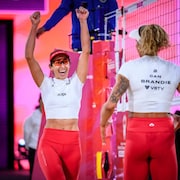 Deux joueuses de volleyball de plage se f&eacute;licitent apr&egrave;s un point gagn&eacute;.