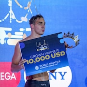 Ilya Kharun tient la couronne et une affiche de r&eacute;compense pour sa victoire.