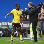 Ismaël Koné, dans l'uniforme jaune et noir de Watford, reçoit des instructions de son entraîneur Slaven Bilic. 