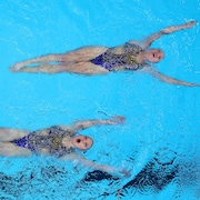 Deux nageuses font une figure dans une piscine.