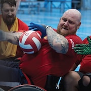 Jean-François Paré tient le ballon lors d'une pratique de rugby en fauteuil roulant.