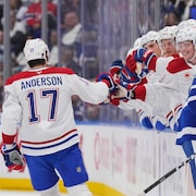 Un joueur de hockey est félicité au banc par ses coéquipiers