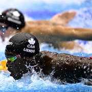 Joshua Liendo nage côte à côte avec son rival lors du 100 m papillon des mondiaux de sports aquatiques de Fukuoka, au Japon