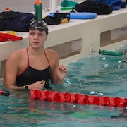 Une nageuse regarde son entraîneur pour obtenir des directives pendant un entraînement.