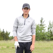 Julien Babineau, debout, avec bâton de golf et casquette.