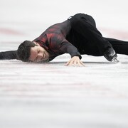 Un patineur effectue sa chorégraphie sur la glace.