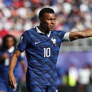 Un joueur de soccer lève le bras gauche.