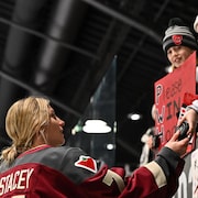 Une joueuse de hockey rencontre des partisans. 