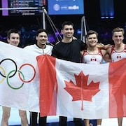 Des gymnastes prennent la pose pour souligner leur qualification olympique. 