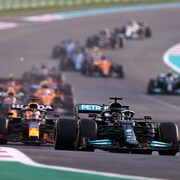 Des voitures de course roulent sur un circuit au départ d'un grand prix.