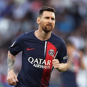 Un joueur de soccer court en regardant au loin.