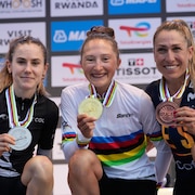 La Canadienne Magdeleine Vallieres-Mill, au centre, gagnante de la course en ligne chez les femmes, est entour&eacute;e sur le podium par la m&eacute;daill&eacute;e d'argent, la N&eacute;o-Z&eacute;landaise Niamh Fisher-Black, &agrave; gauche, et la m&eacute;daill&eacute;e de bronze, l'Espagnole Margarita Victo Garcia Canellas, &agrave; droite, lors des Championnats du monde de cyclisme sur route &agrave; Kigali, au Rwanda, le samedi 27 septembre 2025.