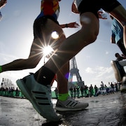 Des coureurs s'élancent devant la tour Eiffel.