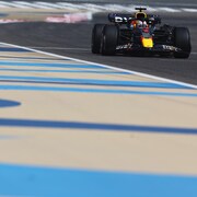 Une voiture roule sur un circuit de F1. 