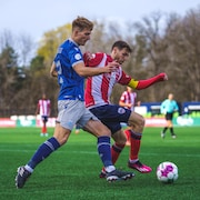 Deux joueurs de soccer se disputent le ballon pendant un mathc.