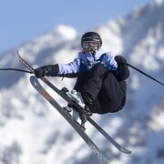 Une skieuse exécute une manœuvre dans les airs.